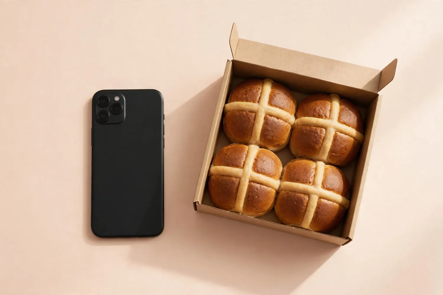 A phone beside a box of buns